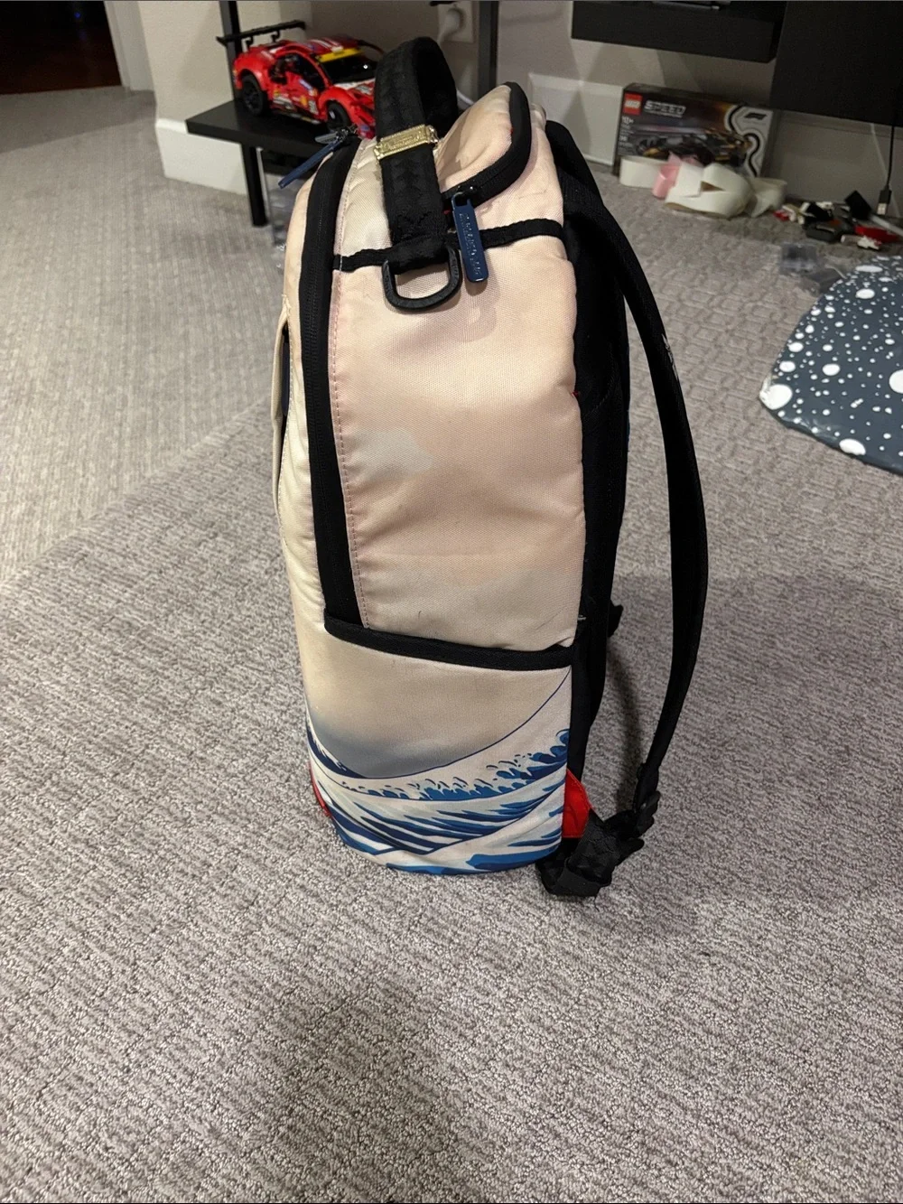 Sprayground Beige Backpack with Blue Wave and Surfing Cartoon